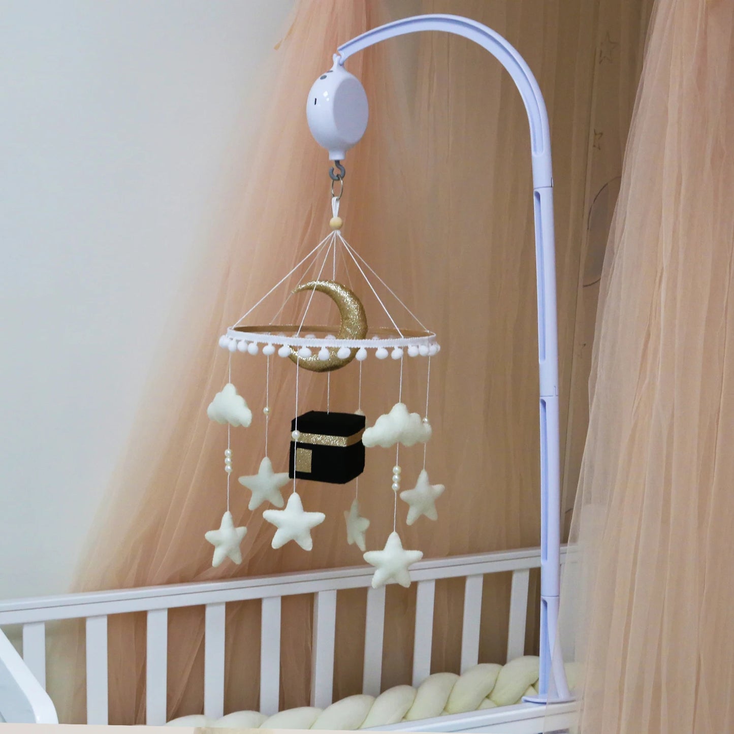 Baby crib mobile with stars, moon, and cloud design hanging above a crib.