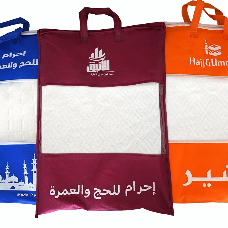 Folded Premium High Quality Ihram for men for hajj and Umrah pilgrimage that comes in a maroon or orange or blue bag.