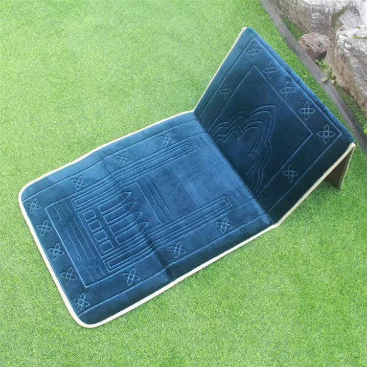 Blue soft memory foam Islamic Prayer mat with back rest and  embossed patterns on a grassy surface