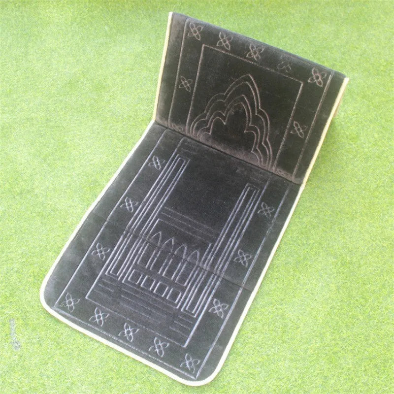 Black soft memory foam Islamic Prayer mat with back rest and  embossed patterns on a grassy surface
