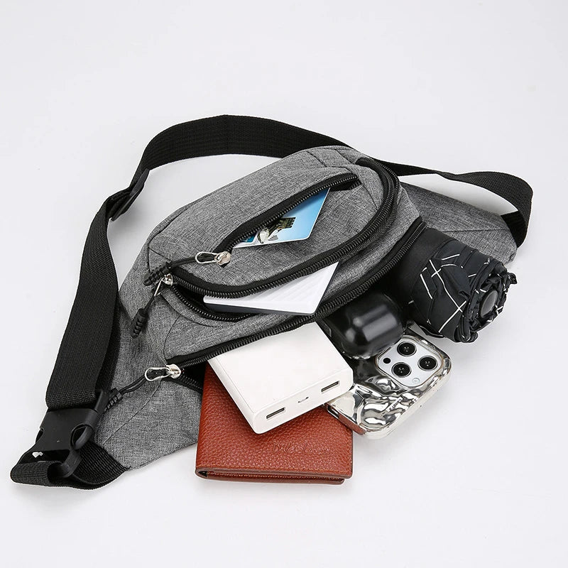 Gray waist bag with black strap containing a phone, power bank, ear pods , wallet, and umbrella to show as to what you can carry during hajj and umrah pilgrimage on a light gray background