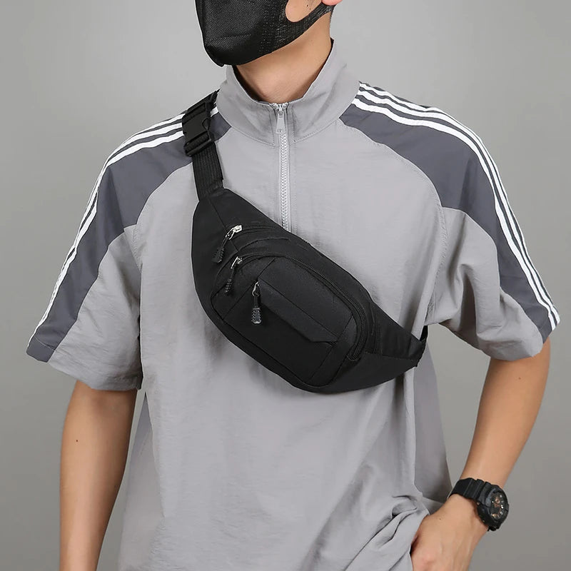 Person wearing a black waist bag for hajj and umrah pilgrimage and gray athletic outfit with white stripes on a gray background