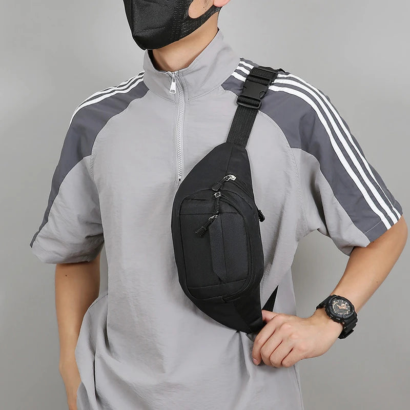Person wearing a gray and black athletic outfit with a black sling bag for haj and umrah on a gray background