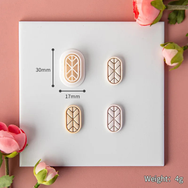 Four geometric mold and clay art on a white card with measurements and weight displayed, surrounded by pink flowers.