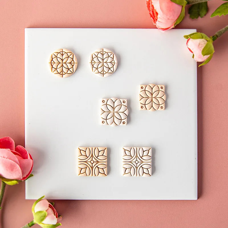 Clay Diy mold with floral patterns on a white tray with pink flowers on a pink background