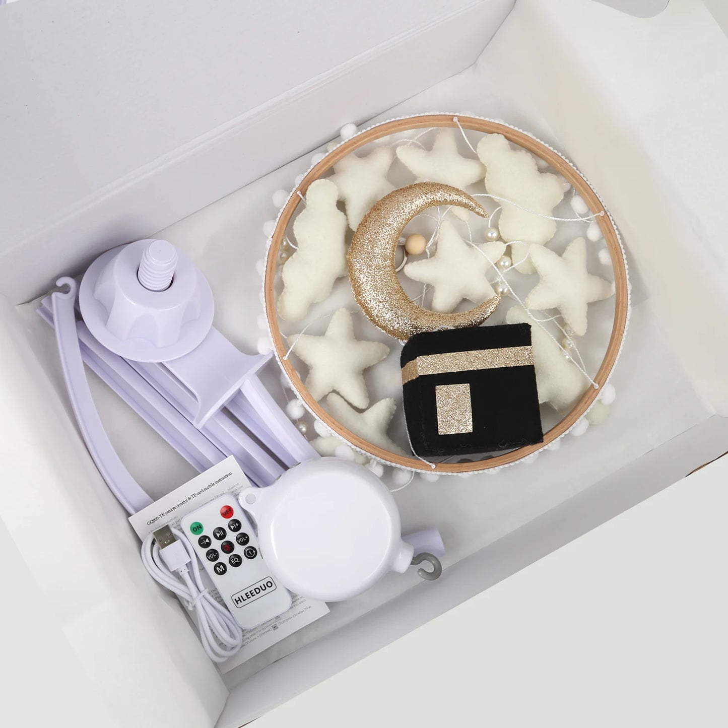 Decorative set with stars, moon, and Kaba with remote control and music box in a box on a white background