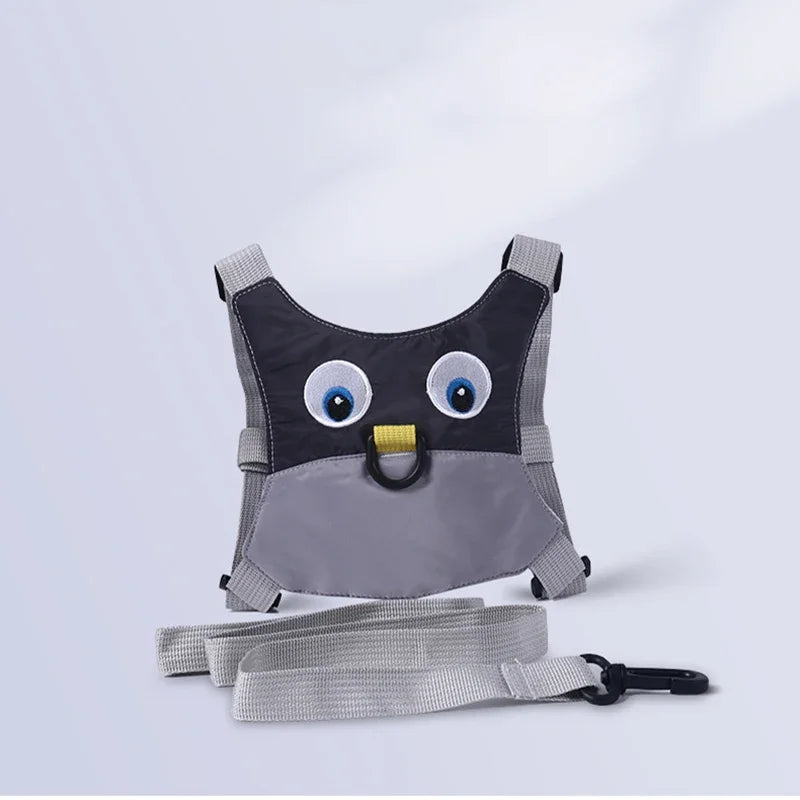 Children's penguin-themed harness with googly eyes and a yellow beak on a light gray background