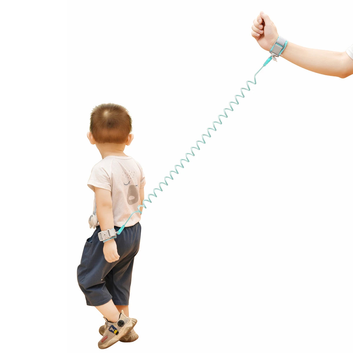 Child wearing a safety harness with a hand holding the other end on a white background