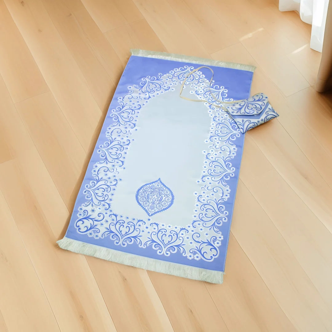 Blue Portable Islamic prayer mat with white patterns on a wooden floor
