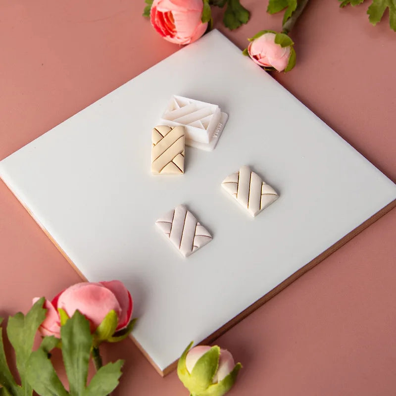 Three triangular ceramic clay Molds on a white plate with pink flowers on a pink background