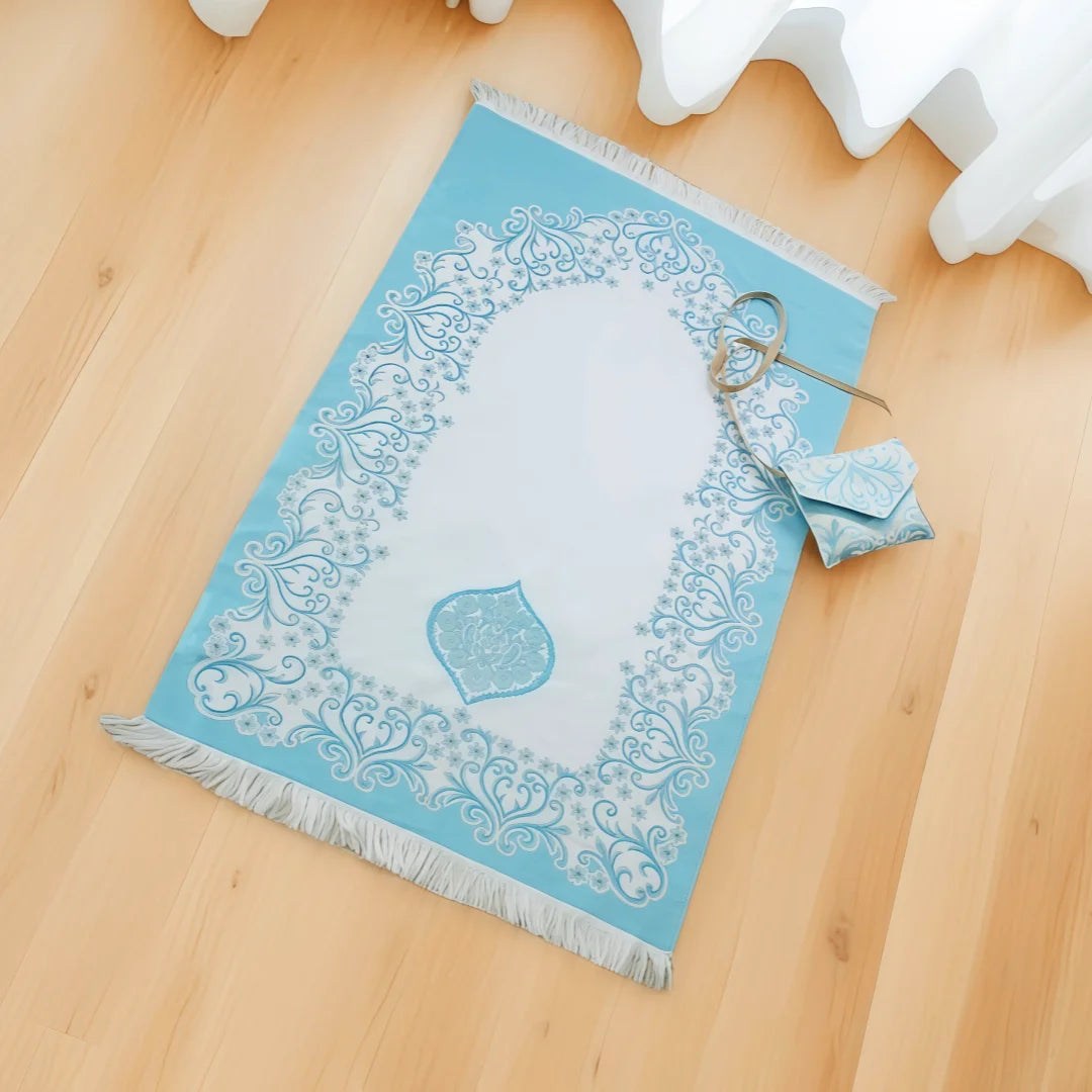 Blue Portable Islamic prayer mat with white patterns on a wooden floor
