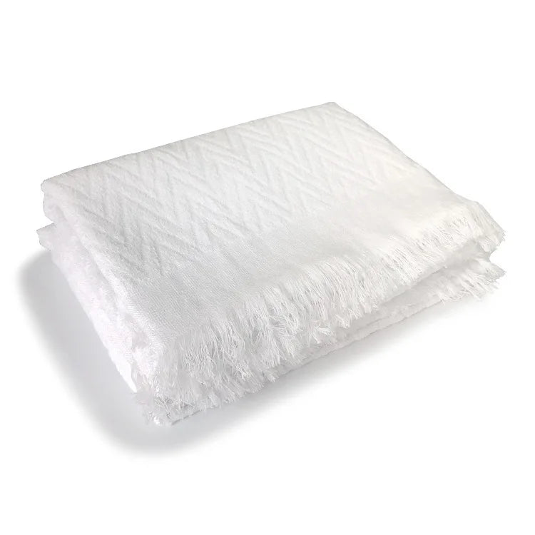 White ihram for hajj and umrah pilgrims with fringe details draped over a person on a white background